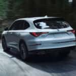 2026 Acura MDX drivin g through the forest backroads