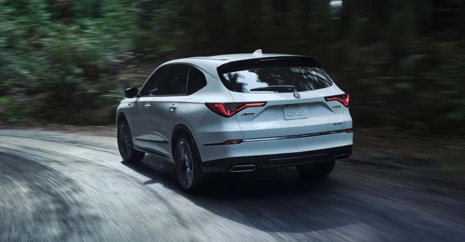2026 Acura MDX drivin g through the forest backroads