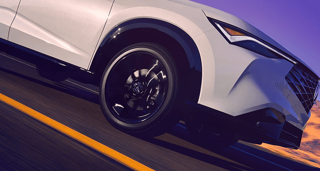 2026 Acura ADX in white driving on highway, front wheel and fender detail