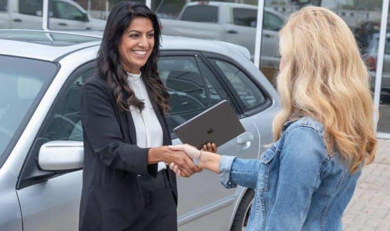 Two women shaking hands after a deal is made.