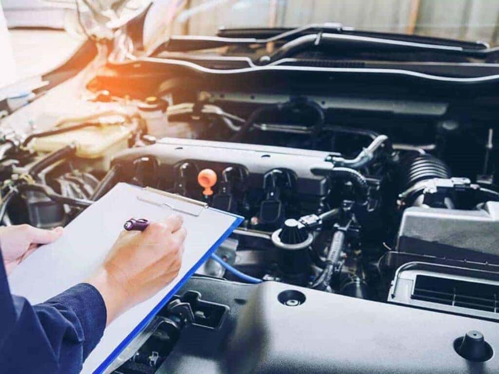 A Maintenance Worker Looking At A Car Engine