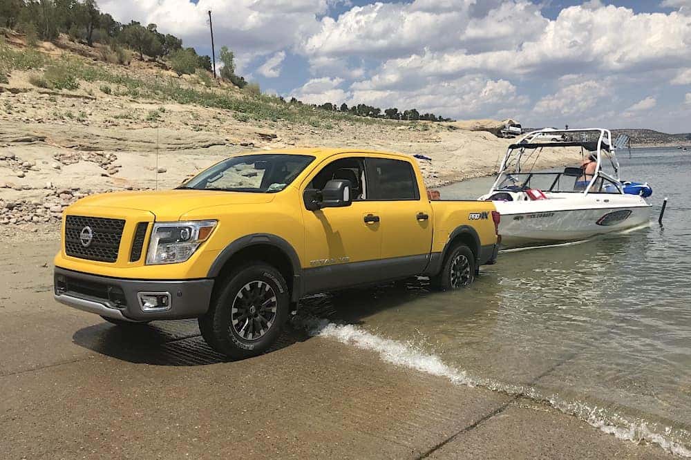 2018 Nissan Titan PRO-4X Solar Flare Yellow with a wakeboard boat