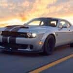 The Swift And Sleek 2019 Dodge Challenger Racing On The Highway, With A Sunset On Its Back