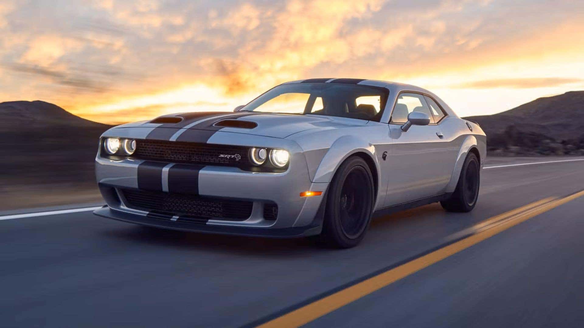 The Swift And Sleek 2019 Dodge Challenger Racing On The Highway, With A Sunset On Its Back