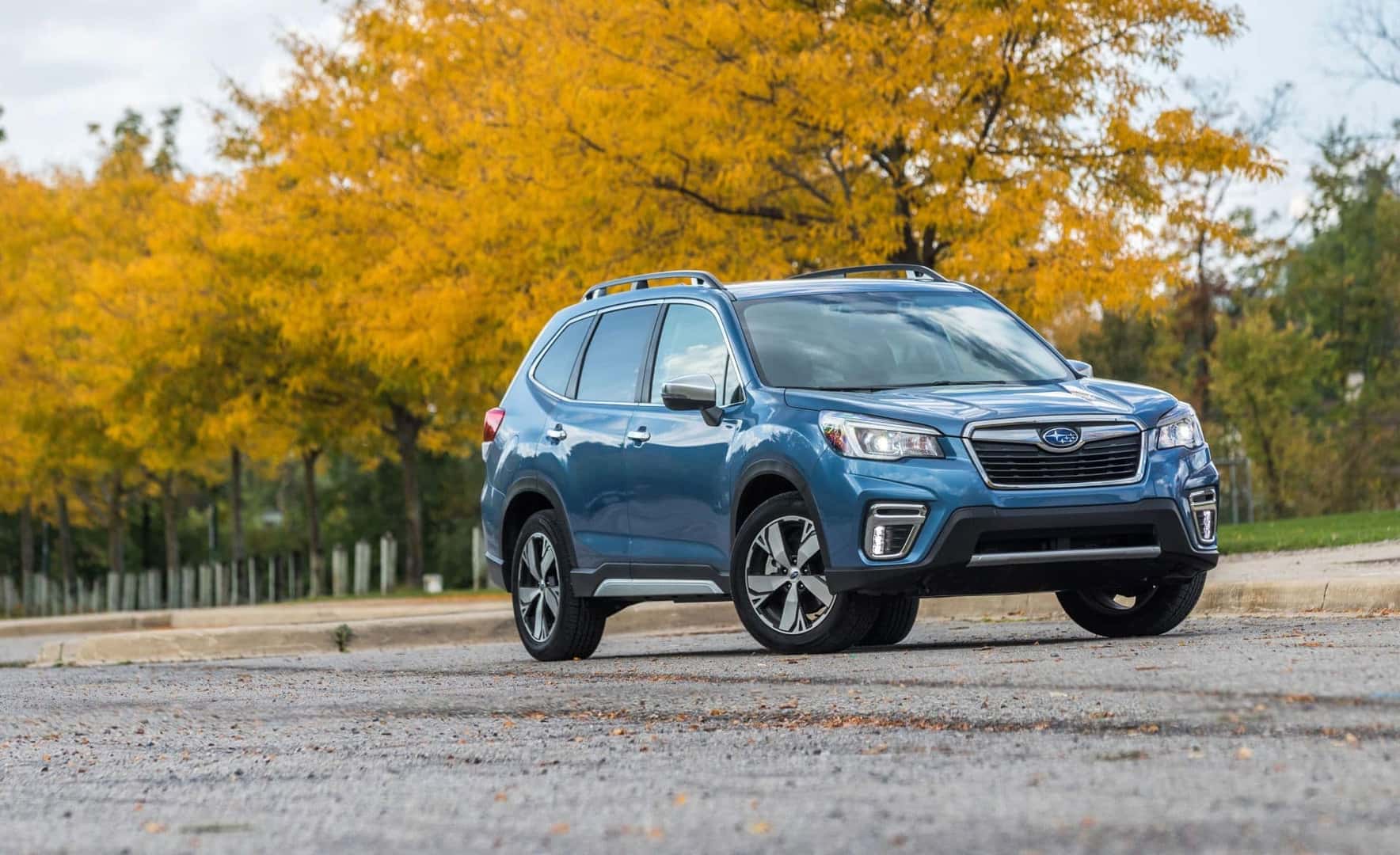 A Gorgeous Blue 2019 Subaru Forested Strolling Past A Park In The Fall Season
