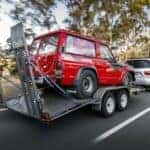 A Vehicle Towing A Nissan Car, Safely And Securely In A Trailer