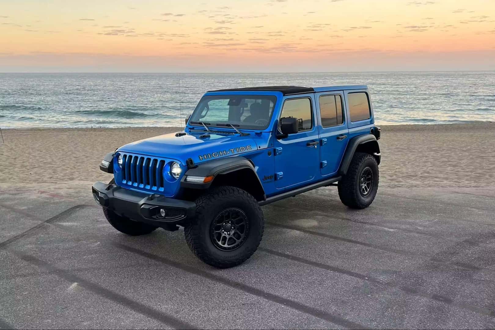 A Blue And Adventurous 2022 Jeep Wrangler, Parked On The Edge Of The Ocean