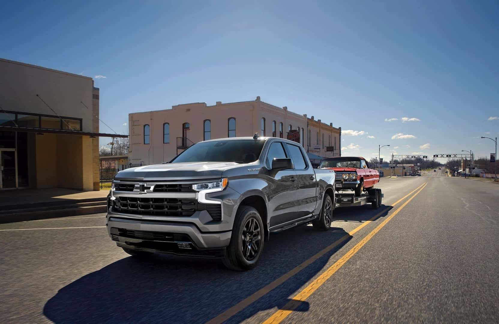 The Towing Master And A Best-Selling Pickup Truck, The 2026 Chevy Silverado, Towing A Car Through Sunny Downtown