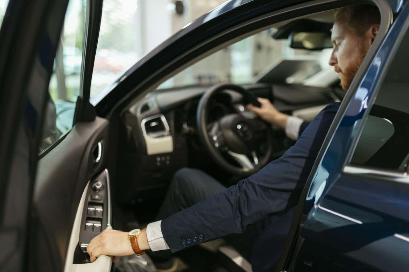 A Driver Closing The Car Door Of His Newly Purchased Used-Car He Bought From The Car Dealership