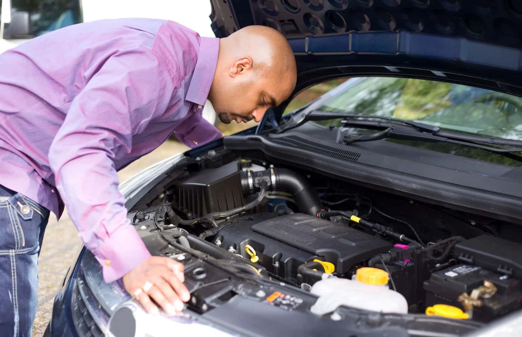 A Customer Inspecting A Used Car Engine To See If It Runs Well And Reliably