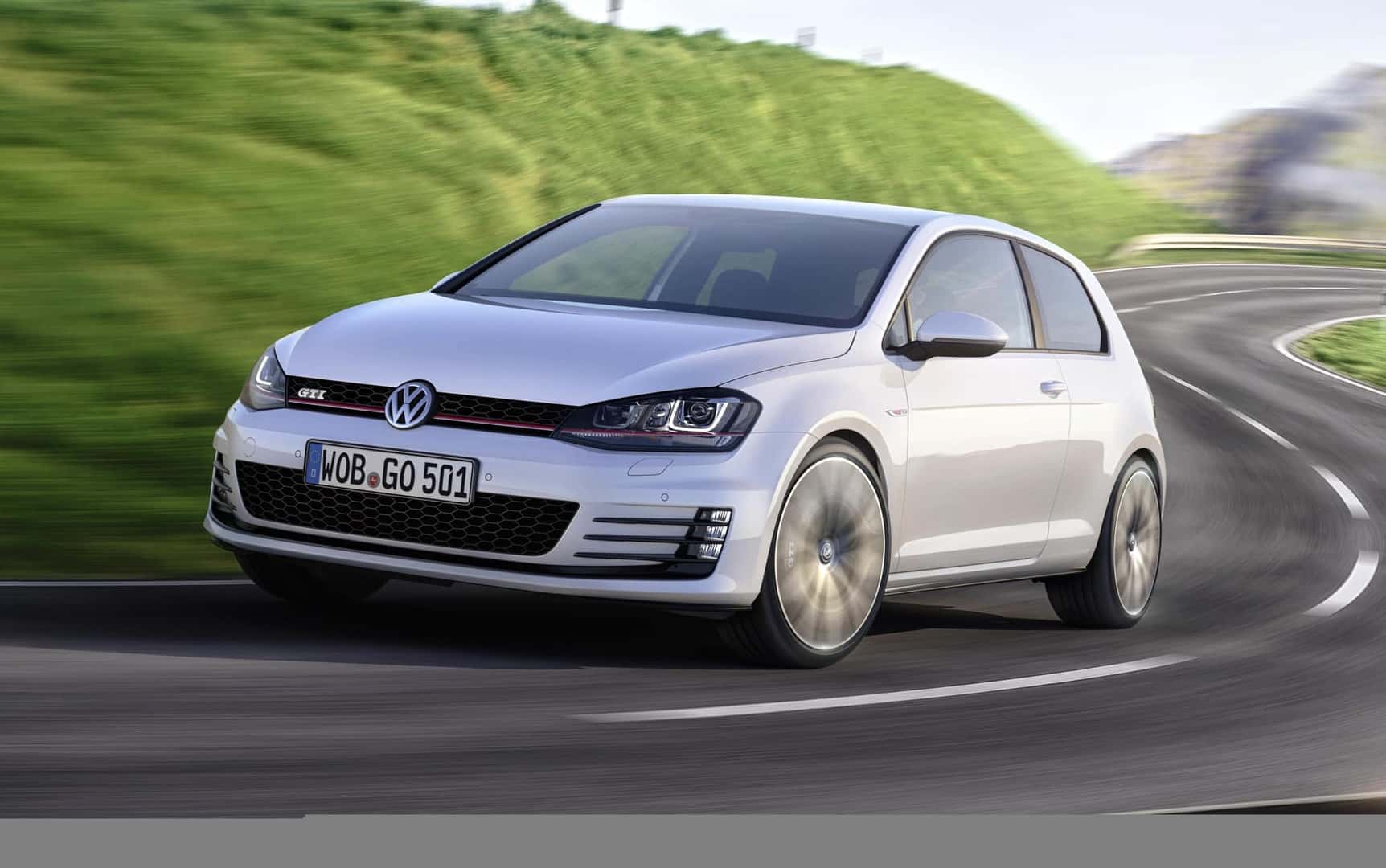 The Inexpensive And Budget Friendly Volkswagen Golf GTI Driving The Twists And Turns Of A Winding Road, Past Beautiful Green Hills