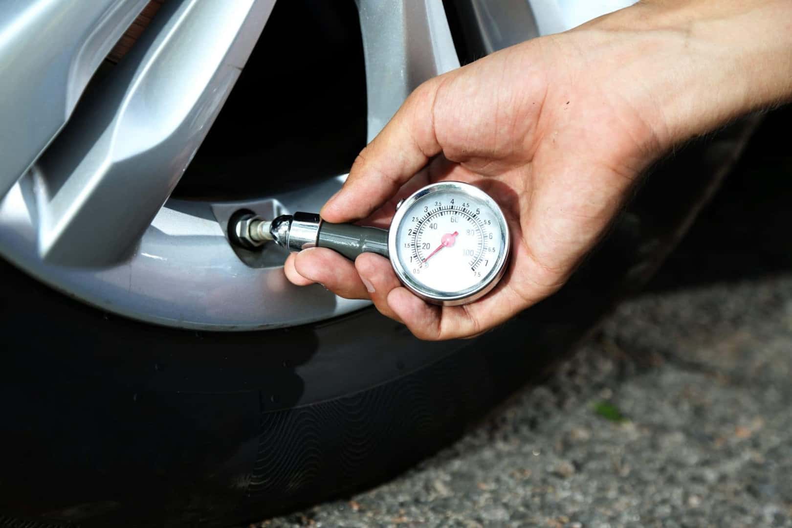 A Driver Upkeeping Their Truck's Maintenance By Doing A Tire Pressure Check