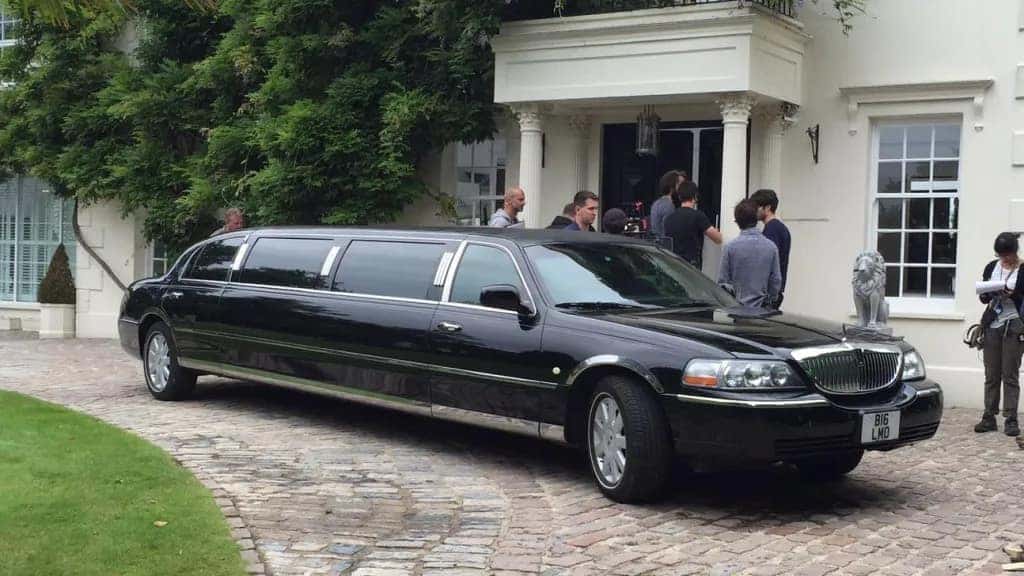 A Stretched, Black, and Luxurious Limousine In Front Of A White House