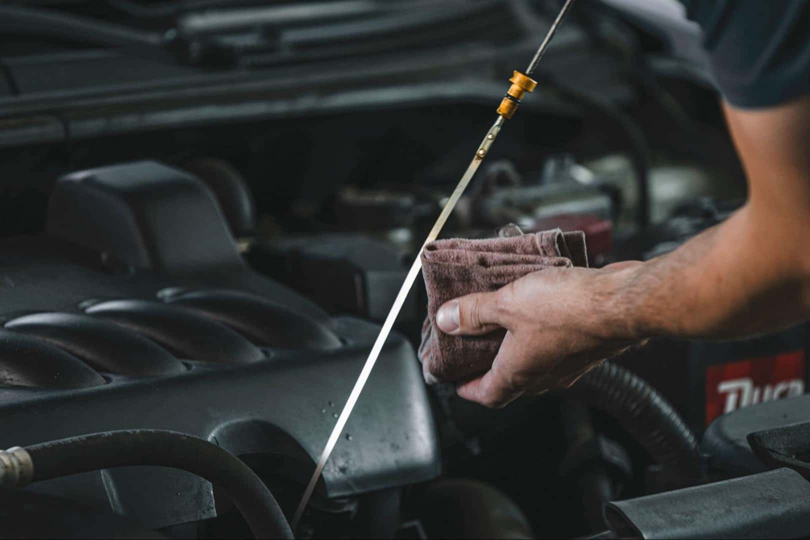 An Ordinary Man Checking His Oil To Upkeep His Truck's Maintenance