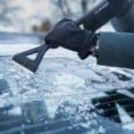 Person scraping ice off of a windshield