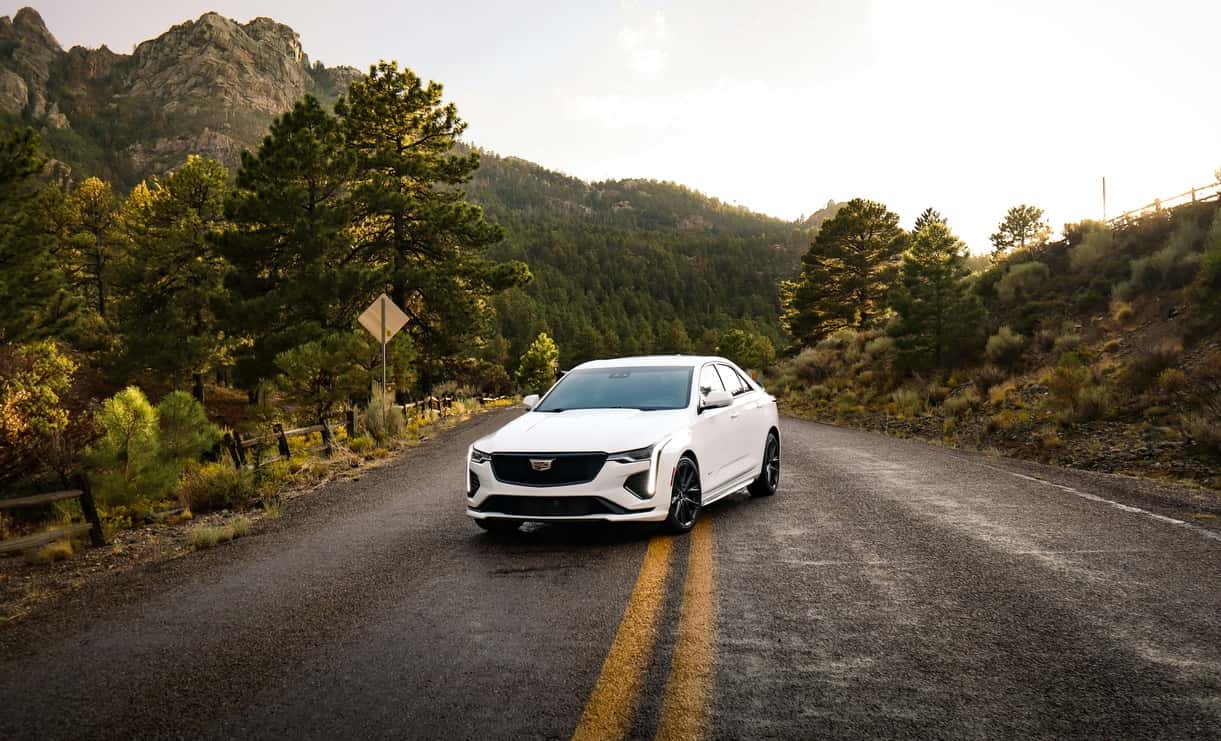 White Sedan on Mountain Road During Daytime