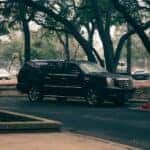 Black Cadillac Escalade Parked Under Trees in Fire Zone