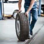 Rolling on the floor. Employee in the blue colored uniform works in the automobile salon