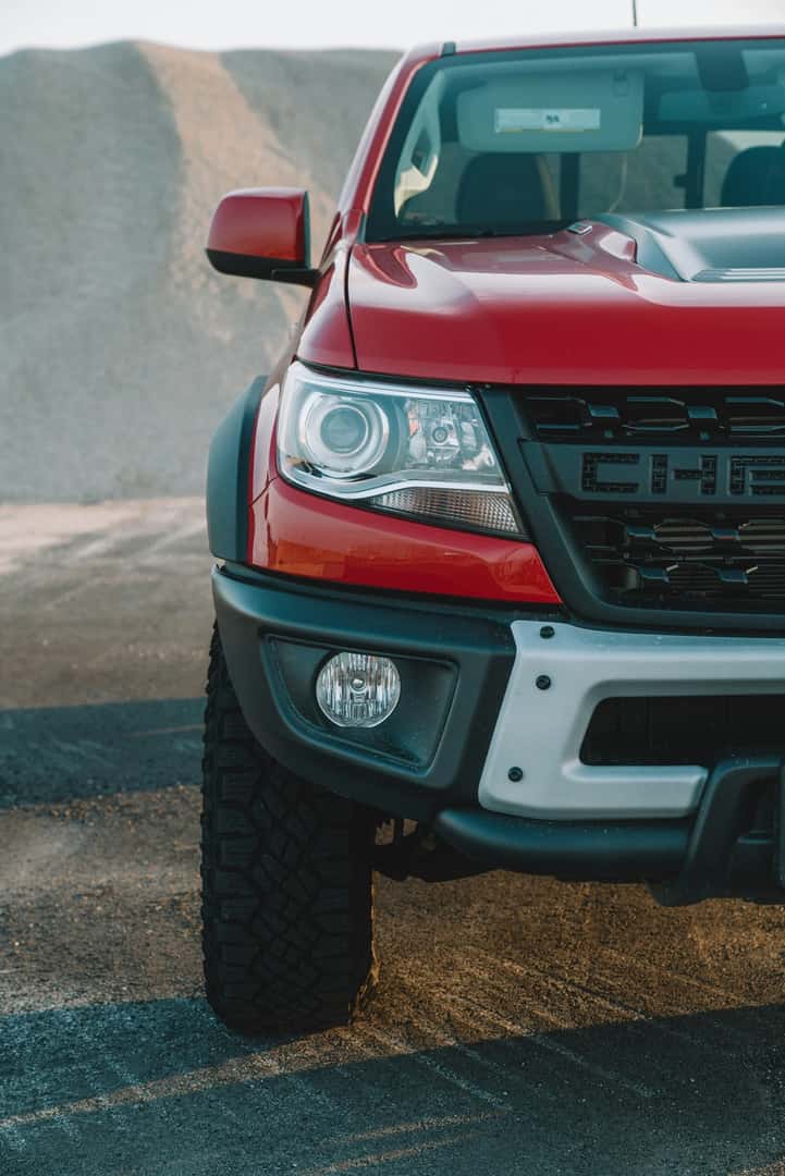 Red Chevrolet truck parked on a gravel road