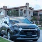 a silver chevrolet suv parked in front of a house