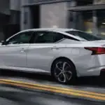 Nissan Altima driving down a city road