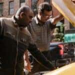 Multiethnic men repairing car on street