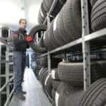 Man in Black Jacket Standing Beside Black Tires