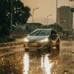 a car driving down a rain soaked street
