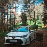 white Toyota car parked near trees during daytime