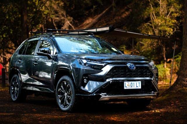 a black toyota rav parked in the woods