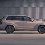 A profile view of a silver Volvo XC90 parked in front of a building.