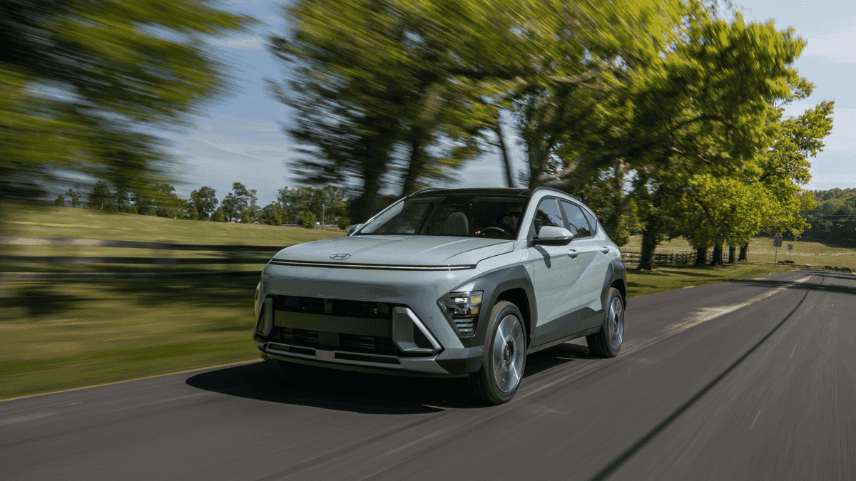 2025 Hyundai Kona cruising through a tree-lined road, highlighting its advanced driver-assist features perfect for Athens roads.