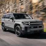 2025 Hyundai Santa Fe driving past a rocky cliffside, showcasing its durability and maintenance-friendly design for Athens, GA drivers.