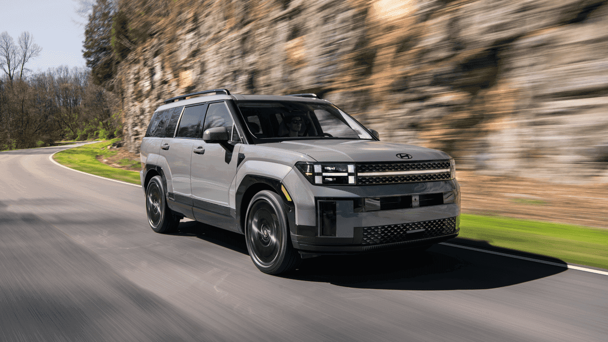 2025 Hyundai Santa Fe driving past a rocky cliffside, showcasing its durability and maintenance-friendly design for Athens, GA drivers.