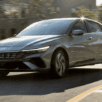 2025 Hyundai Elantra driving through city streets, built for daily commuting with smart features for Athens, GA professionals.