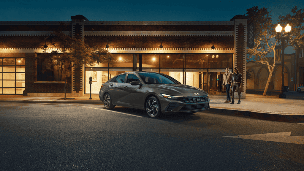 2025 Hyundai Elantra Hybrid driving on an open road near Athens, GA, showcasing aerodynamic design and fuel efficiency