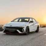 2025 Hyundai Elantra N parked on an open desert road at sunset, showcasing its sporty design and performance-focused styling.