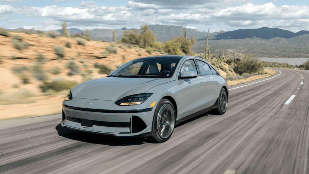 2025 Hyundai IONIQ 6 electric sedan cruising along a desert highway, showcasing aerodynamic styling and EV innovation.