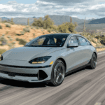 2025 Hyundai IONIQ 6 electric sedan cruising along a desert highway, showcasing aerodynamic styling and EV innovation.