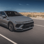 2025 Hyundai Sonata Hybrid gliding on a highway with modern LED headlights and bold front-end design.