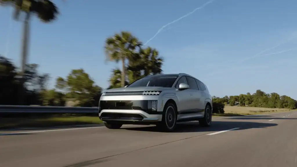 2026 Hyundai IONIQ 9 electric SUV driving past palm trees, highlighting futuristic styling and zero-emissions power.