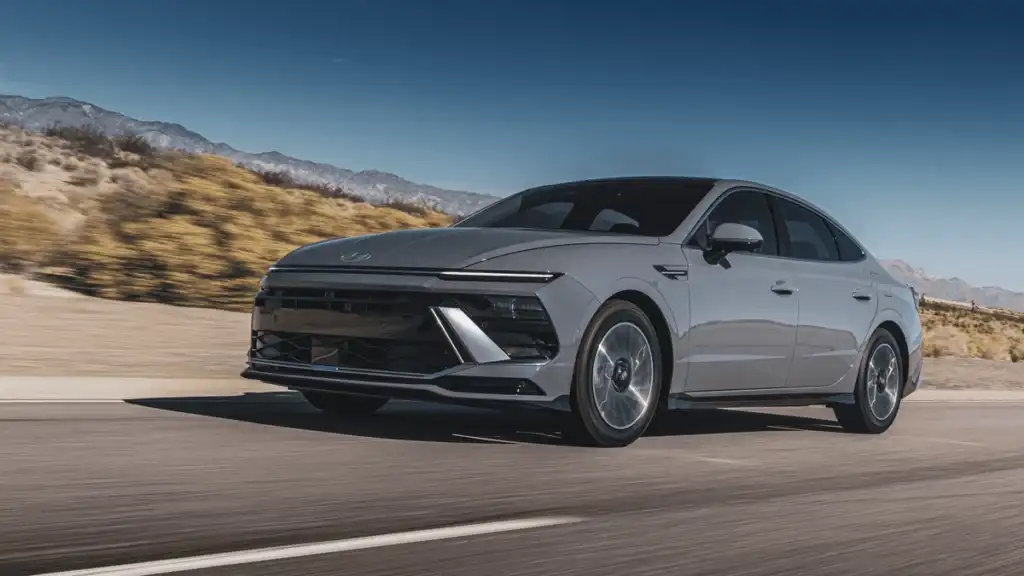 2025 Hyundai Sonata Hybrid driving through a desert highway, presenting its sleek silhouette and hybrid powertrain benefits.