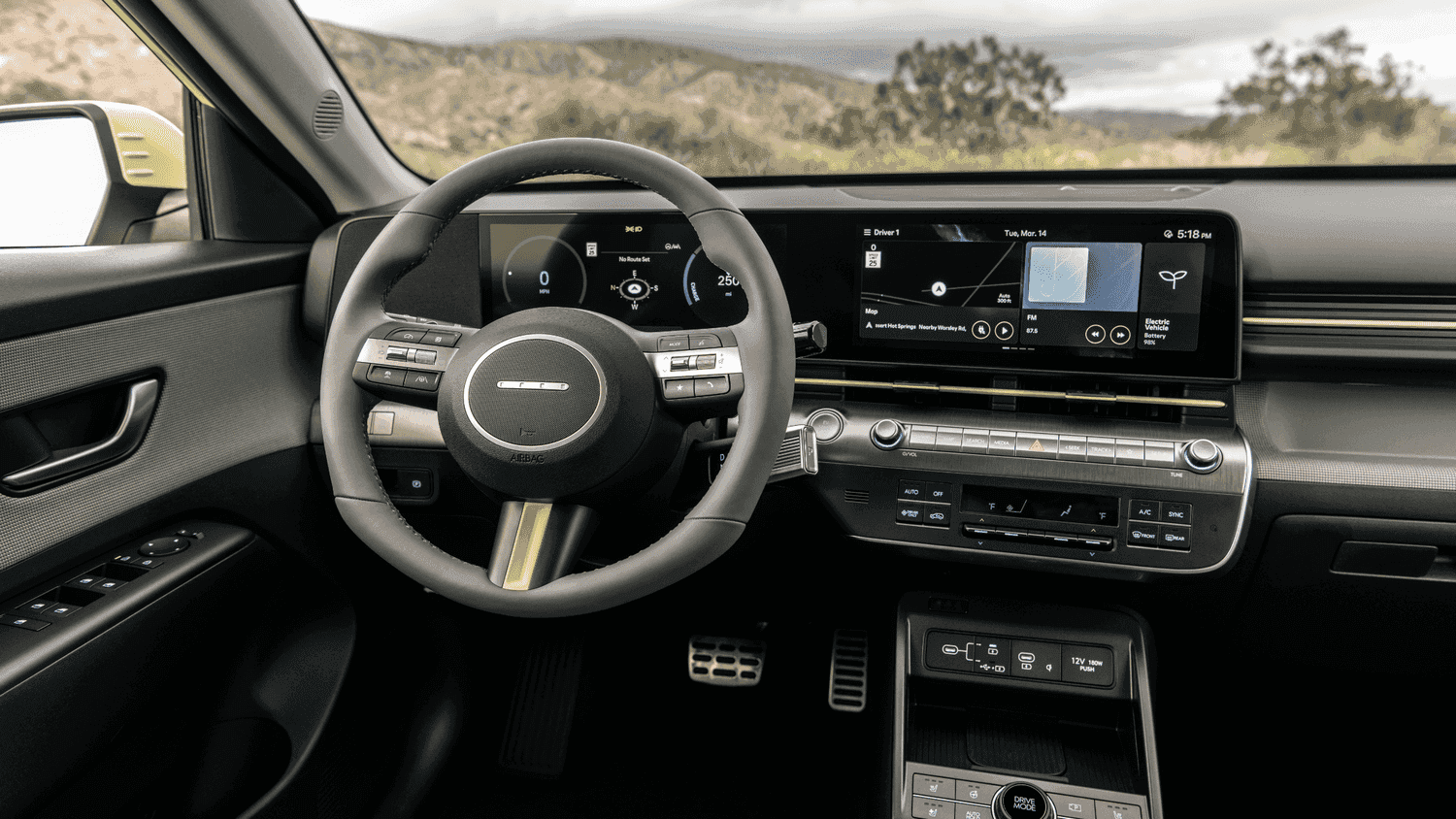 Driver’s seat view of the 2025 Hyundai Kona Electric featuring navigation and energy efficiency data in Athens, GA.