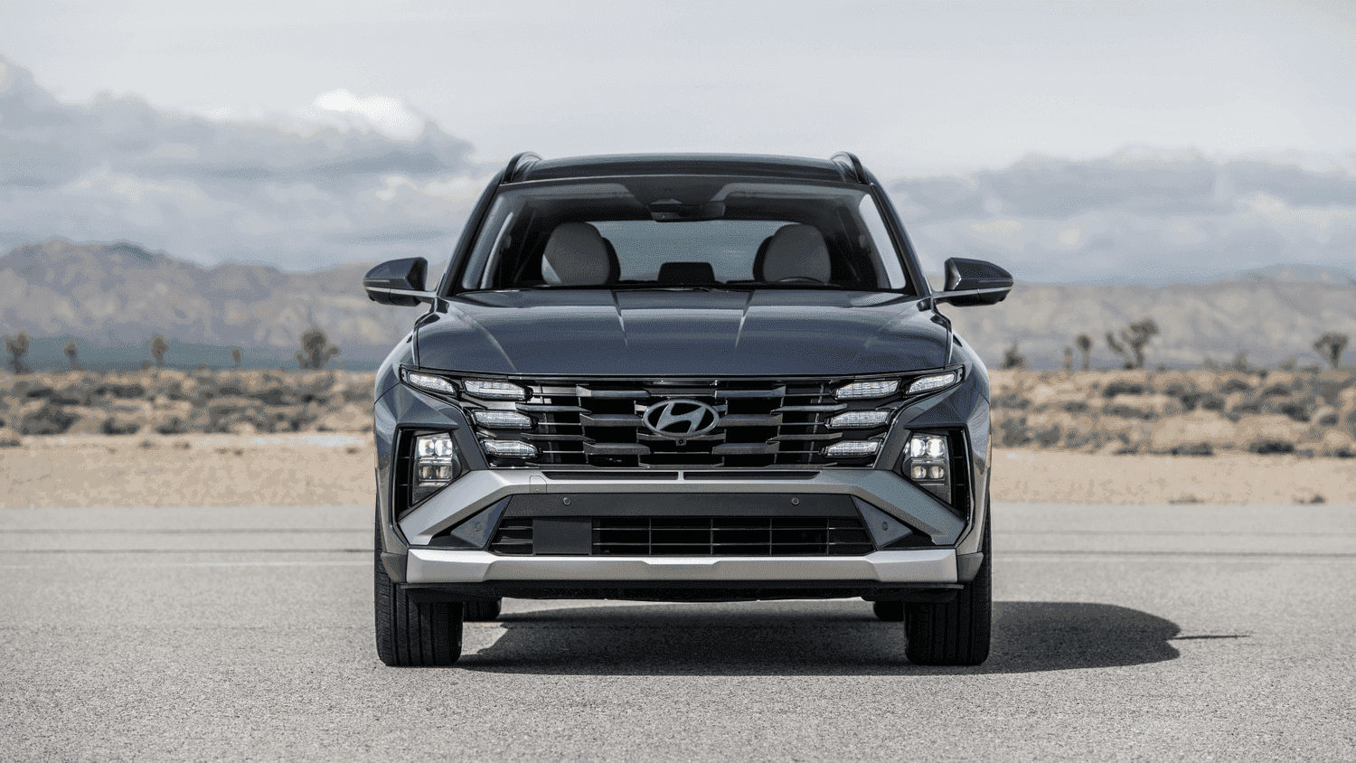 Sharp, futuristic front grille of the 2025 Hyundai Tucson, captured in a scenic Georgia desert-like background near Athens.