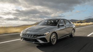 2025 Hyundai Elantra sedan driving on an open road near Loganville, GA, showcasing its sleek design and fuel-efficient performance.