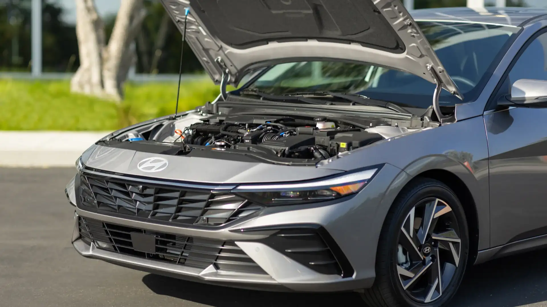 2026 Hyundai Elantra front view with hood open, showcasing engine bay and modern grille design.