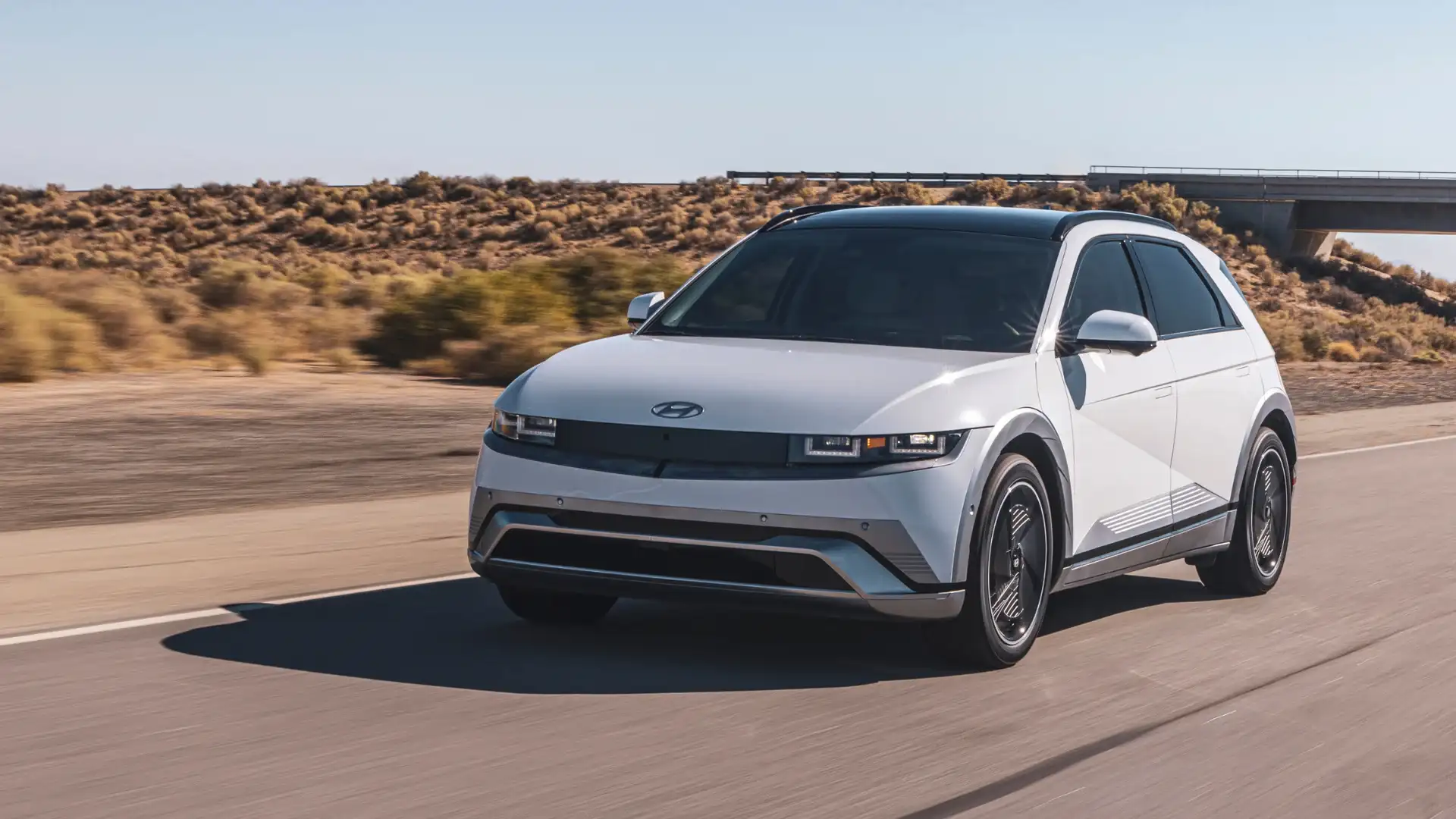 2026 Hyundai IONIQ 5 exterior in white driving on highway with aerodynamic design and LED headlights.