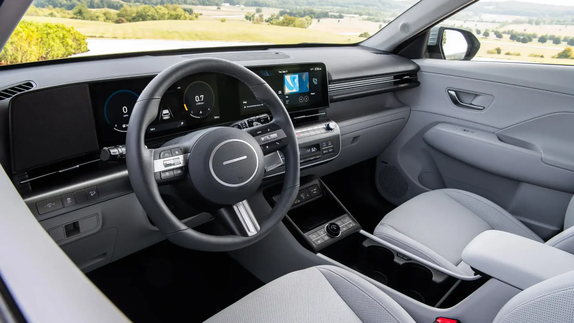 2026 Hyundai Kona front cabin with digital cluster, touchscreen, rotary shifter, and gray upholstery.
