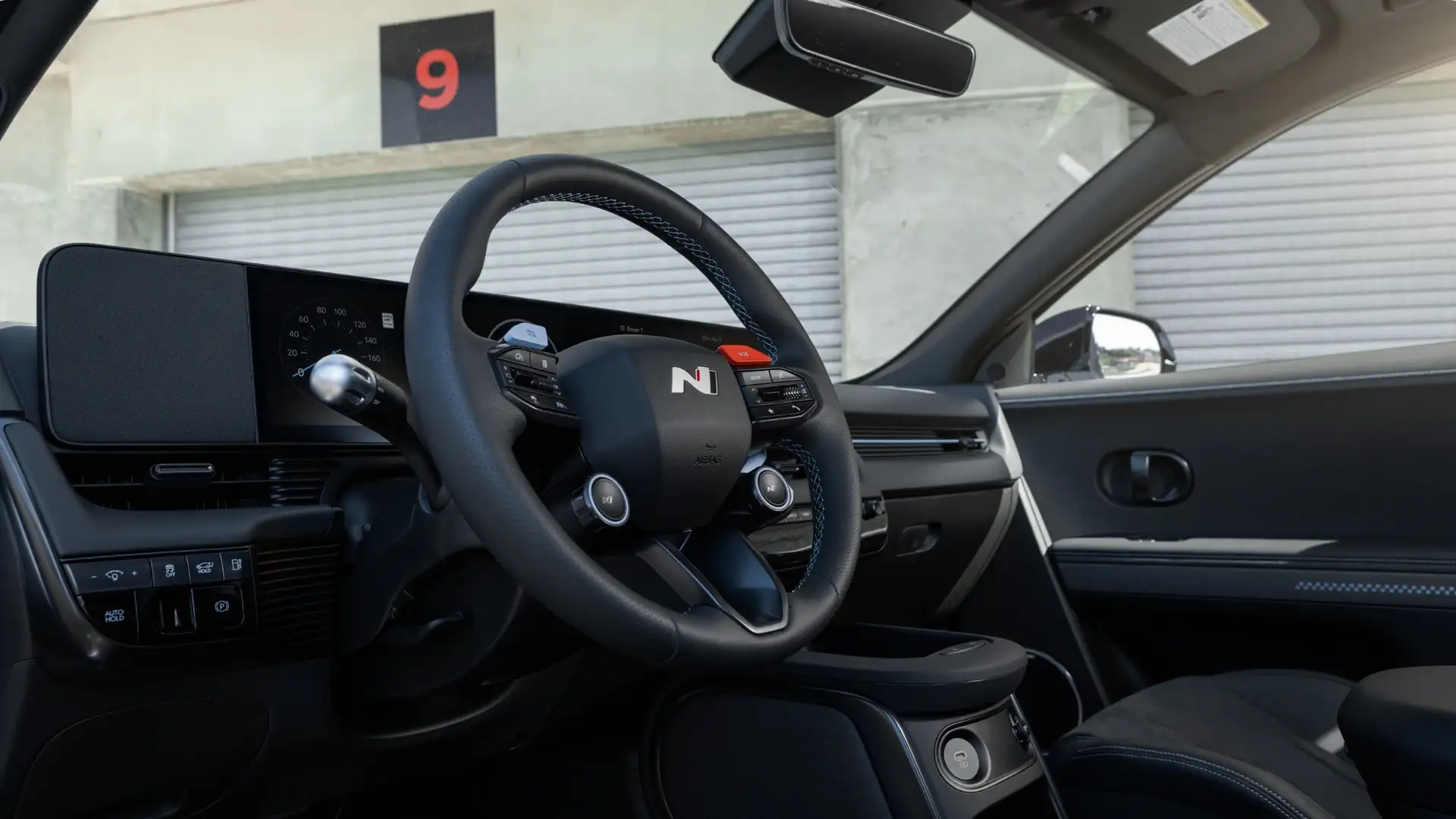 Interior cockpit view of the 2025 Hyundai IONIQ 5 N featuring the N-branded steering wheel, dual-screen digital displays, and sporty black cabin detailing.