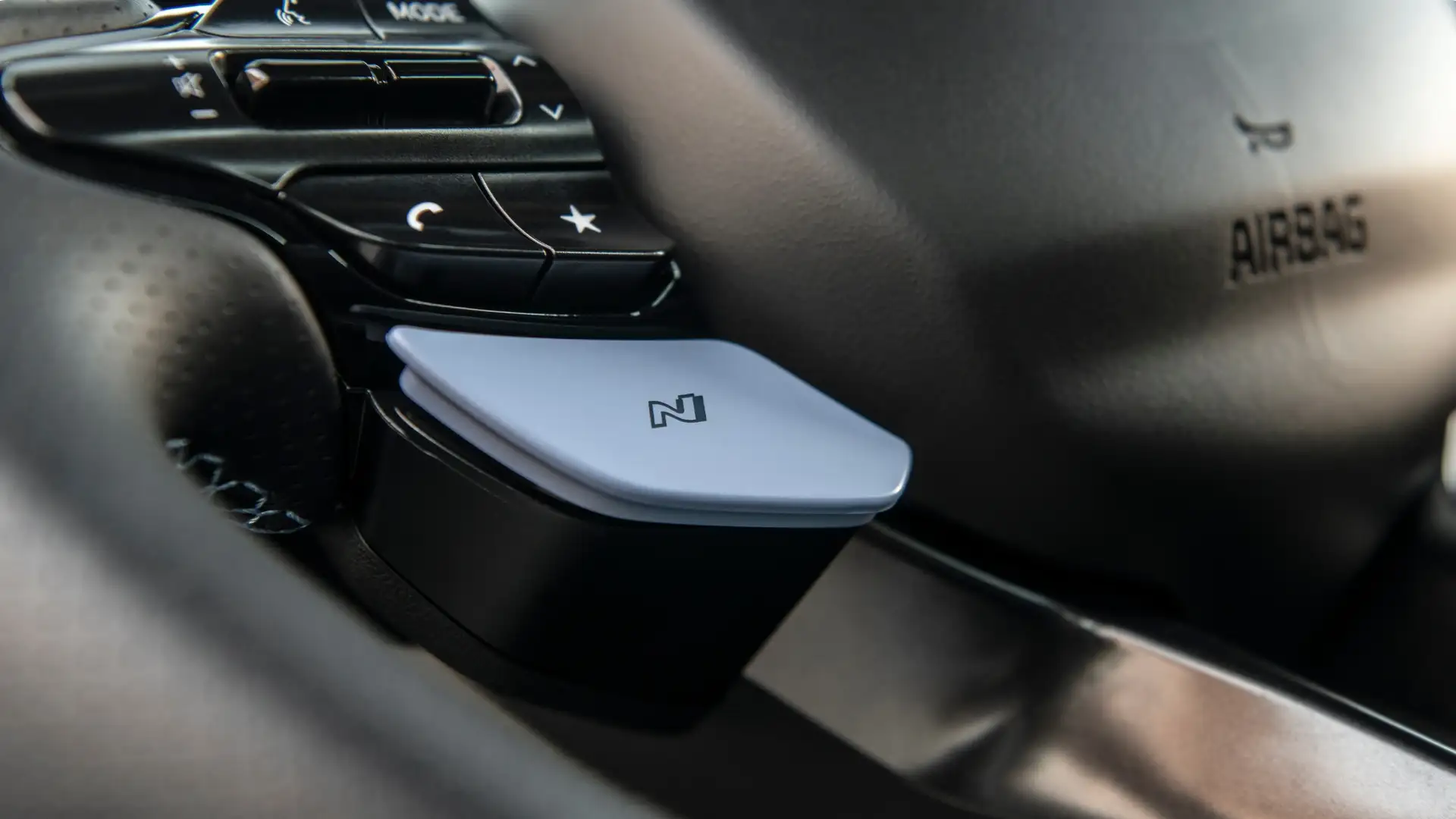 Close-up of the 2026 Hyundai Elantra N steering wheel featuring the signature N Mode button and performance control switches.
